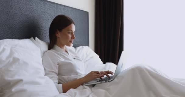 Mujer joven soñadora que se queda en la cama después de despertarse . — Vídeos de Stock