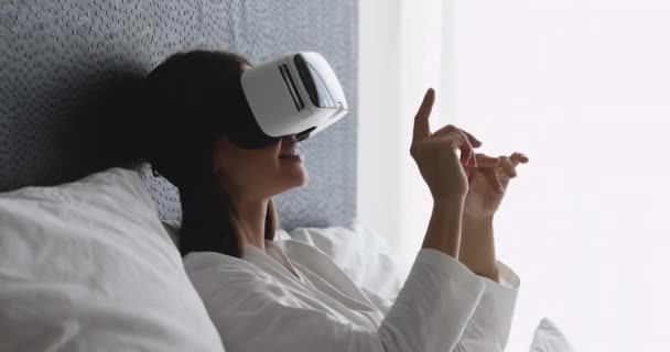 Excited smiling young brunette woman using virtual reality goggles. — Stock Video