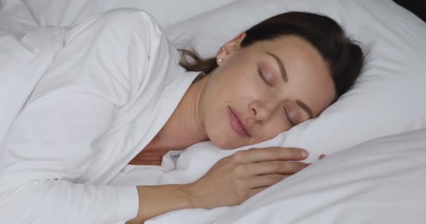 Lycklig vacker dam sover i sängen, dagdrömmer på morgonen. — Stockvideo