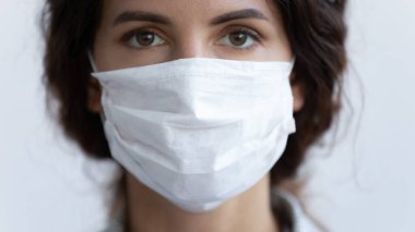 Tıbbi koruyucu maske takan genç bir kadının portresi