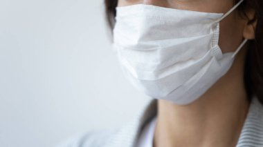 Virüs bulaşmış tıbbi maskeli bir kadın.