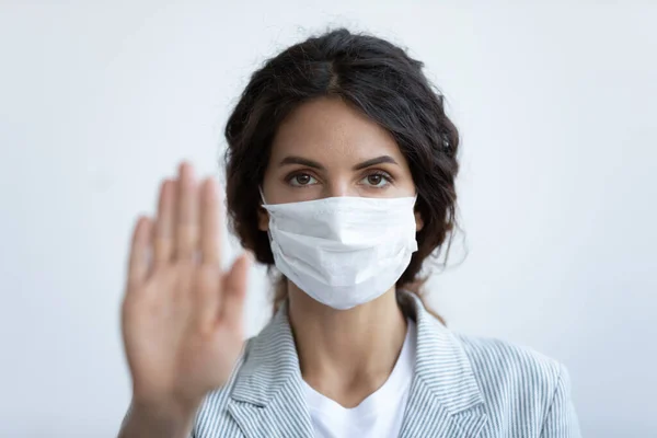 Donna in maschera medica mostra gesto di arresto per fermare la pandemia — Foto Stock