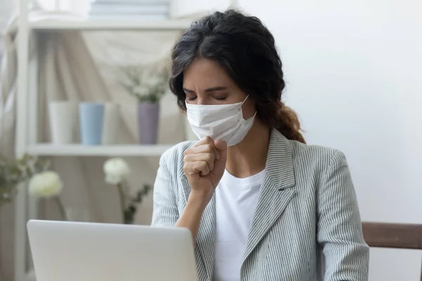 Unhealthy female employee in medical mask cough at workplace — Stock Photo, Image