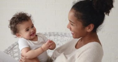 Tatlı melez çocuk annesiyle el çırpıyor.