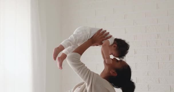 Africano mãe levantando bonito bebê menina se divertindo em casa — Vídeo de Stock