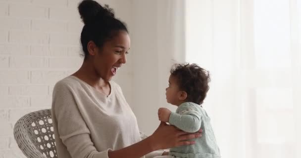 Loving happy mixed race mom playing lifting cute baby daughter — Stock Video
