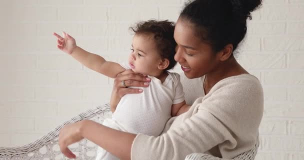 Cariñosa afro-americana mami holding lindo bebé hija mirando lejos — Vídeo de stock