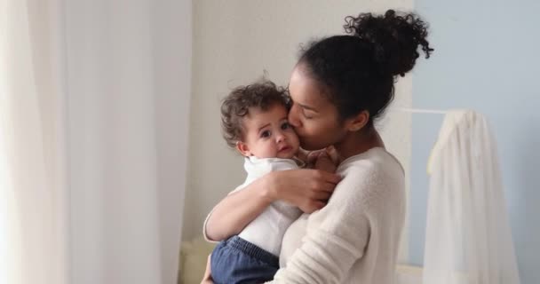 Cariñosa africana mamá holding lindo bebé hija besos pequeño niño — Vídeo de stock