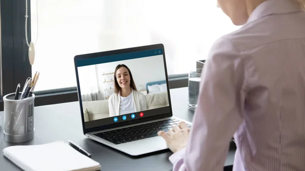 Jovem se comunicando com a irmã sorridente via videochamada . — Fotografia de Stock