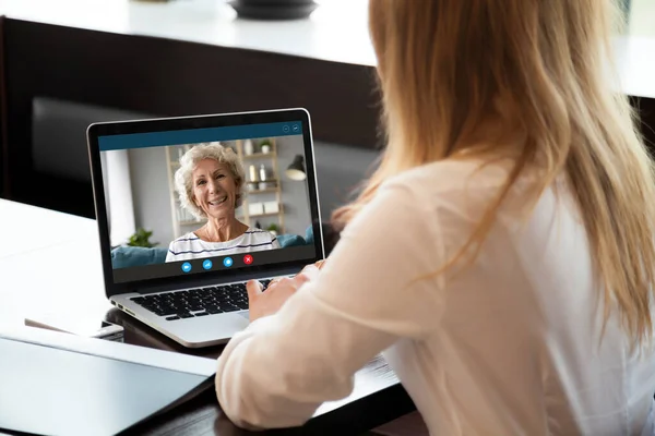 Glückliche Frau mittleren Alters macht Videoanruf mit kleiner Tochter. — Stockfoto