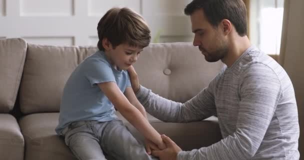 Padre compasivo ayudando a un niño pequeño a lidiar con el acoso escolar . — Vídeo de stock