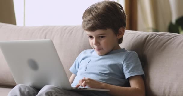 Addicted to technology happy small kid playing game on laptop. — Stock Video