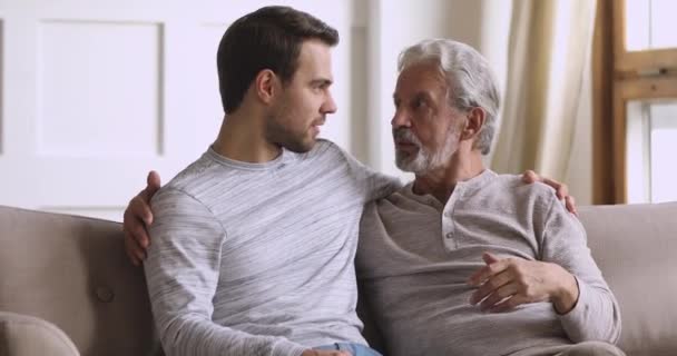 Χαμογελώντας νεαρός άνδρας επικοινωνεί με τον ηλικιωμένο πατέρα στο σπίτι. — Αρχείο Βίντεο