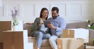 Mutlu aile çifti yeni dairede internetten ev dekorasyonu sipariş ediyor..