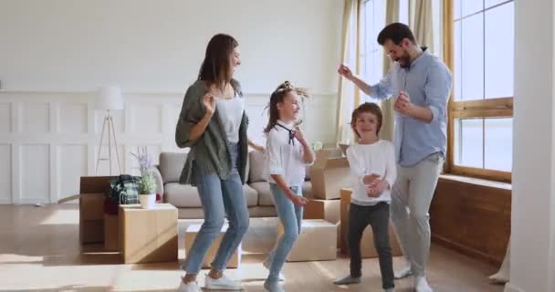 Familie dansen tussen grote kartonnen dozen, vieren bewegende dag. — Stockvideo