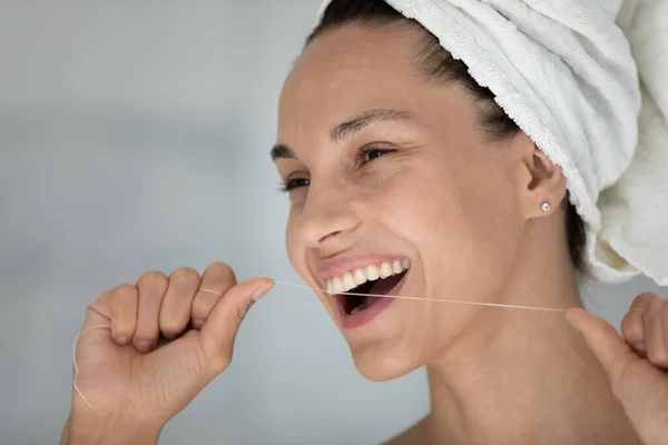 Beautiful smiling 30s woman holding dental floss cleaning teeth