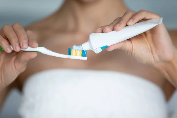 Closeup view woman squeezes toothpaste to toothbrush from tube — Stock Photo, Image