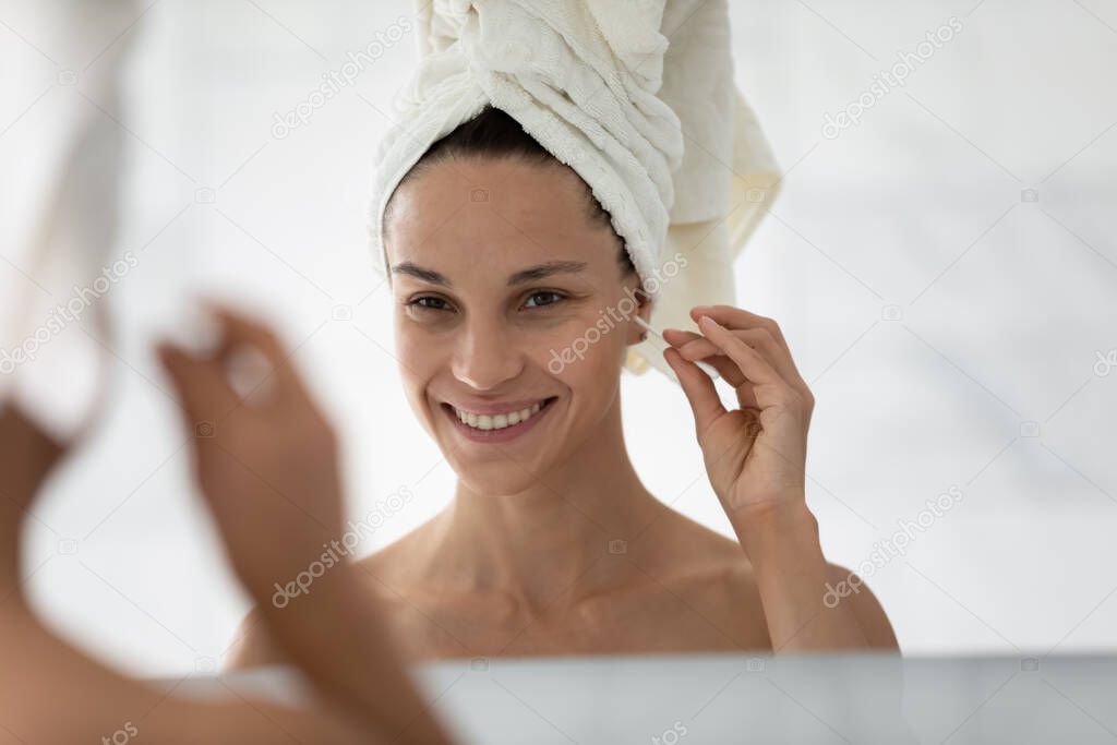 Woman do morning routine holding cotton bud cleans ears