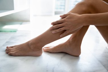 Kadın yumuşak ipek bacaklara dokunur Epilasyon işleminden sonra derinin tadını çıkarır