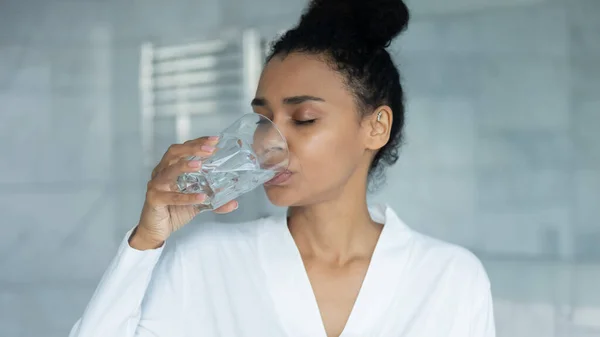 Femme africaine tenant verre boire encore de l'eau le matin — Photo