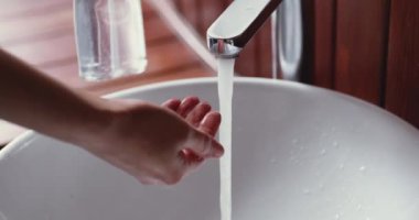 Genç kadın ellerini sıvı sabun dezenfektanı jeliyle yıkıyor.