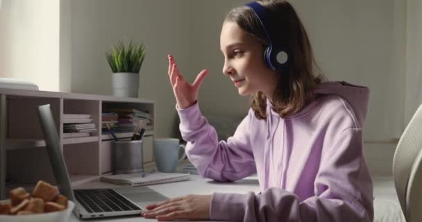 Kulaklık takan liseli kız öğrenci laptopta konferans veriyor. — Stok video