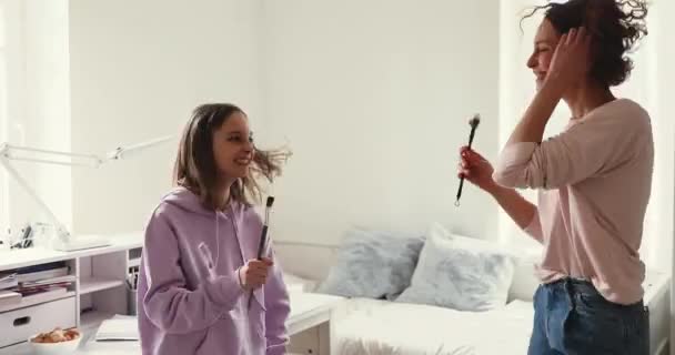 Счастливая мама и дочь-подросток танцуют, поют вместе дома — стоковое видео