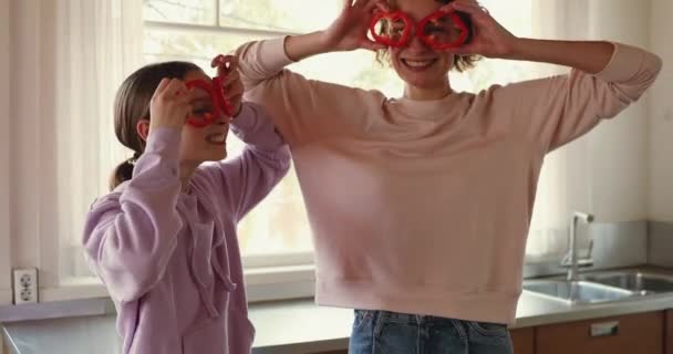 Funny young mom and teenage daughter making pepper glasses — Stock Video