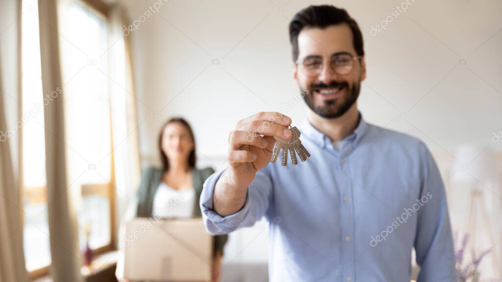 Excited married family couple celebrating moving day in new apartment.