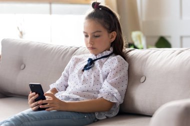 Ciddi küçük liseli kız evde tek başına akıllı telefon uygulamaları kullanıyor..