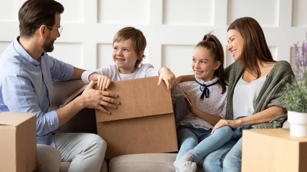 Leende par som har roligt med barn efter att ha flyttat in lägenhet. — Stockfoto