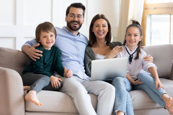 Gelukkig gezin met kinderen ontspannen op de bank met computer. — Stockfoto