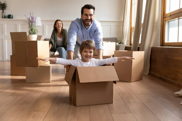 Happy young father pushing carton box with small kid son. — Stock Photo, Image