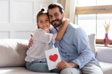 Gülümseyen babayı kucaklayan küçük tatlı bir kızın portresi, doğum günü kutlaması..