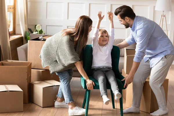 Маленький мальчик празднует покупку новой мебели с родителями . — стоковое фото