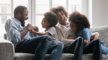 Afrikalı etnik çift küçük kız ve oğlanı gıdıklıyor.