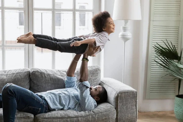 African father lift son, kid imitates plane flying in air — Stock Photo, Image