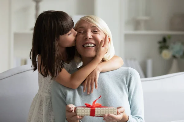 Liten jente gjør bursdagsoverraskelse til opphisset voksen bestemor – stockfoto