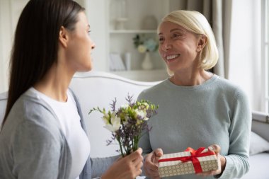 Sevgi dolu yetişkin kız, büyük anneyi doğum günüyle selamlıyor.