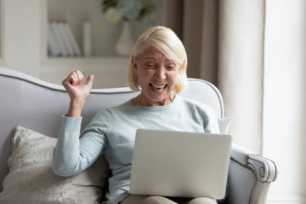 Alegre mujer mayor se siente eufórico ganar en línea — Foto de Stock