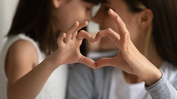 Young mother and little daughter posing making heart gesture — Stock Photo, Image