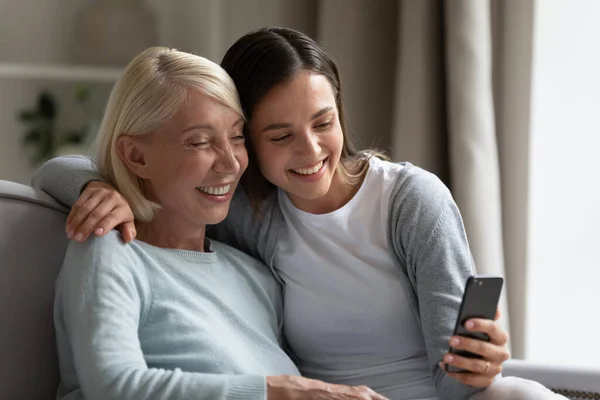 Smiling senior mom and grown-up daughter take selfie together — Stock Photo, Image