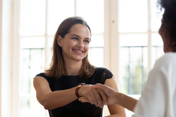 Различные женщины-брокеры и клиенты пожимают руку на деловой встрече — стоковое фото
