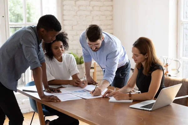 Líder de equipo caucásico comparte idea de proyecto con compañeros de trabajo multiétnicos — Foto de Stock