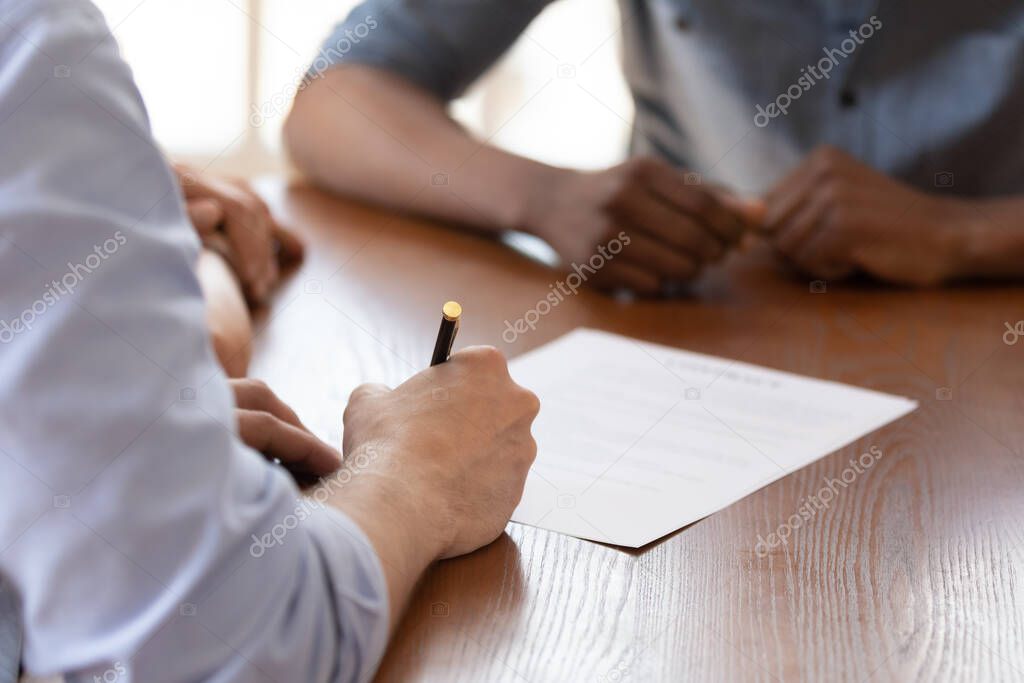 Couple during meeting with realtor signing rental agreement closeup image