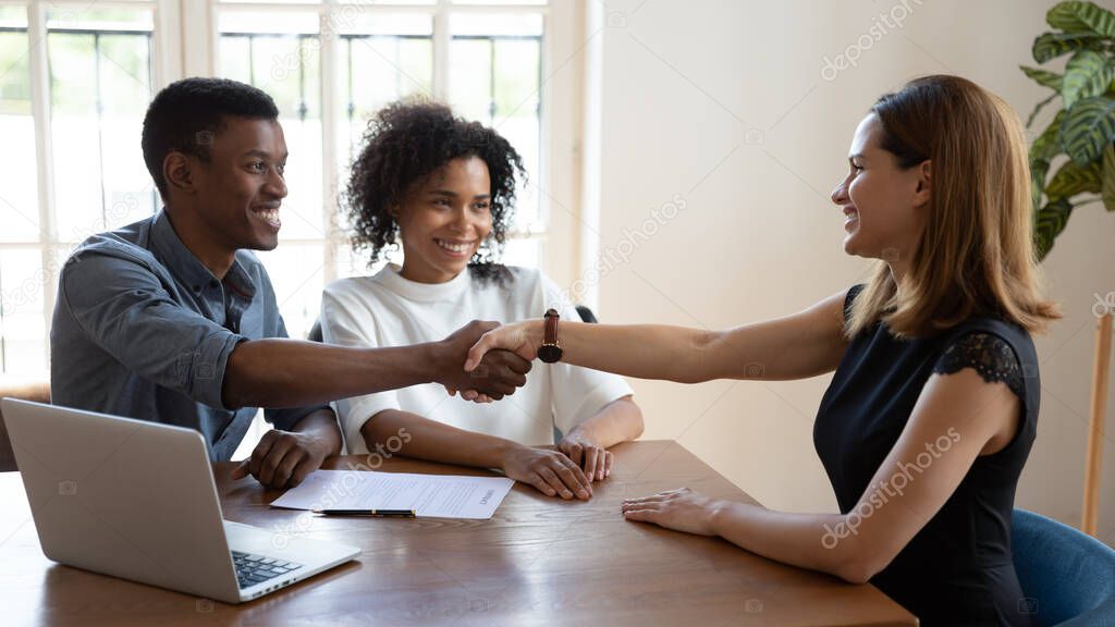 Happy African married couple shake hands to mortgage insurance broker