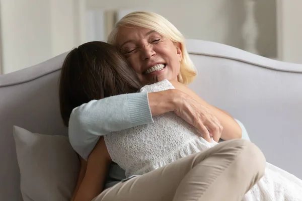 Loving senior grandmother and little granddaughter relax at home — Stock Photo, Image