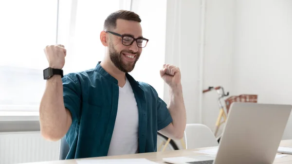 Glückliche männliche Mitarbeiter triumphieren beim Lesen guter Nachrichten auf dem Laptop — Stockfoto