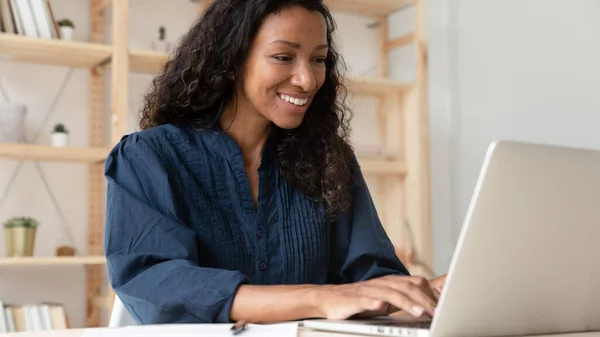 Leende kvinnlig anställd arbetstagare arbetar på laptop på arbetsplatsen — Stockfoto