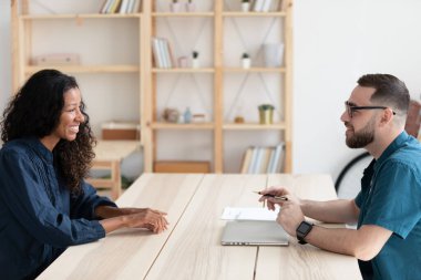 Erkek patron konuşuyor. Çift ırklı kadın başvuru sahibi.